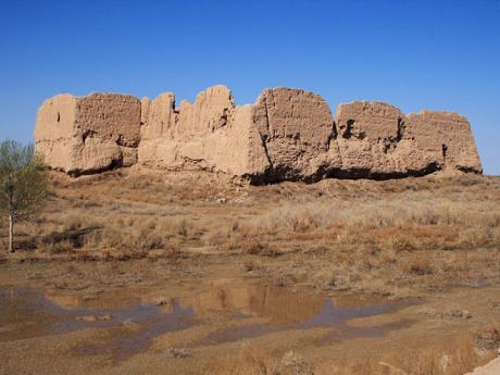 Ruiny bývalého hliněného paláce Kyzyl qala na úpatí pohoří Sultan Uvajs