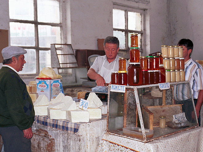 Prodejce medu a domácích sýrů v kryté tržnici ve městě Krujä 
