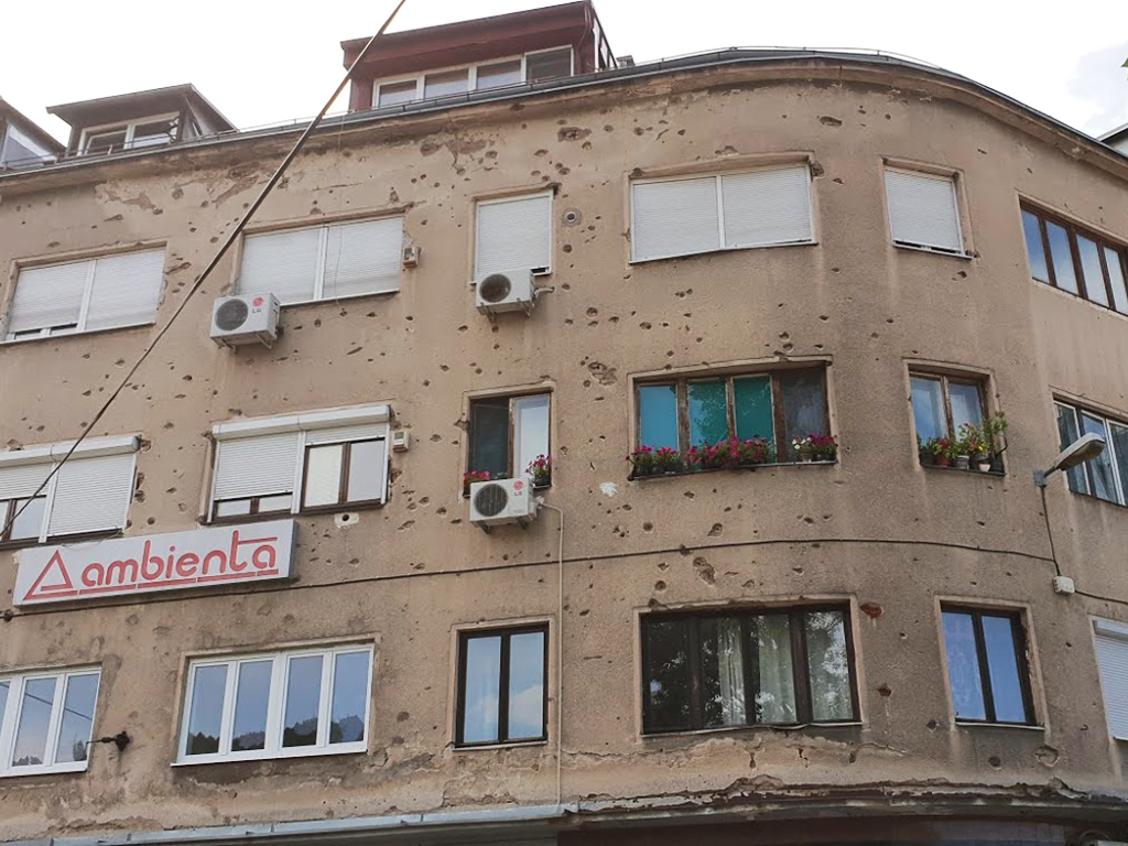 Stopy po kulkách v omítce sarajevských domů stále připomínají válečná léta
