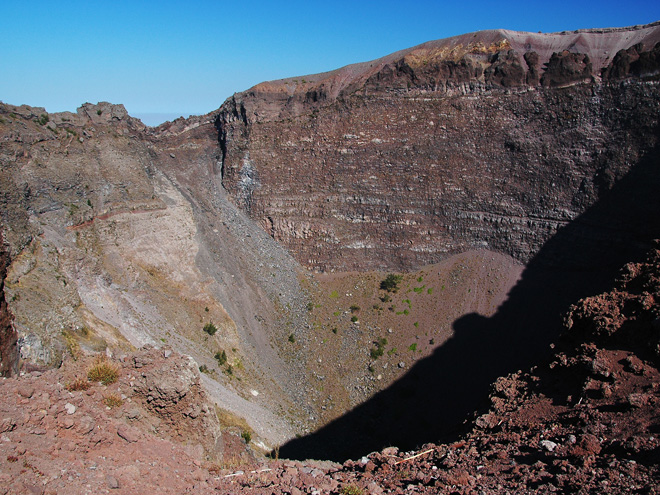 Pohled přes dřevěné zábradlí dolů do kráteru Vesuvu
