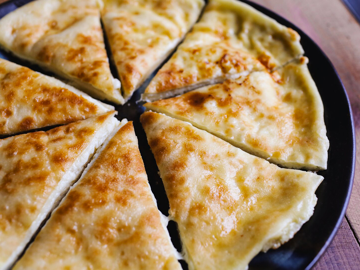 Chlebová placka chačapuri imeruli je plněná slaným imeretským sýrem
