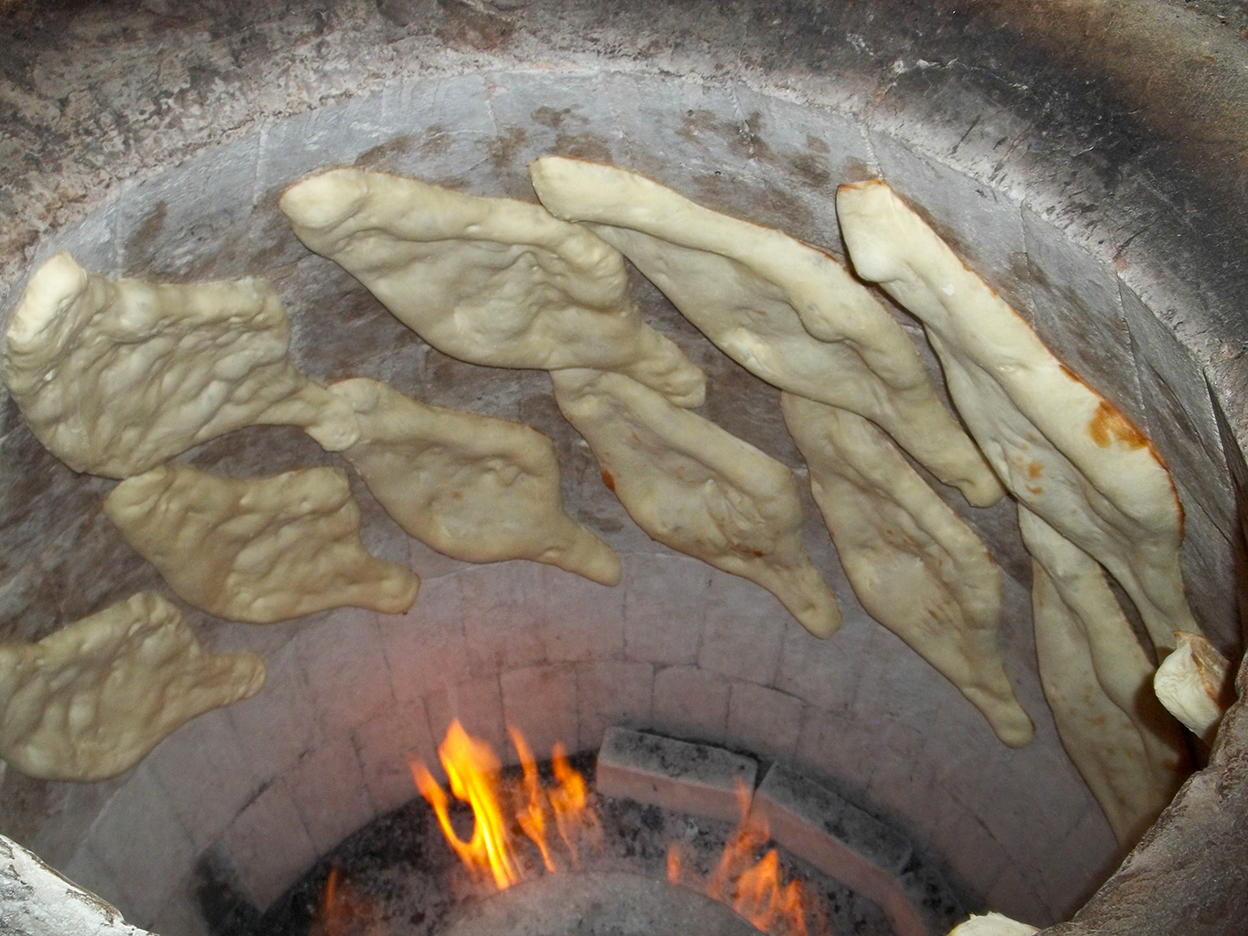 Tradiční gruzínský chléb šotis puri ve tvaru kánoe se peče v hliněné peci tone