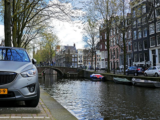 Zaparkovat auto vedle kanálu bez zábradlí v centru Amsterdamu je umění