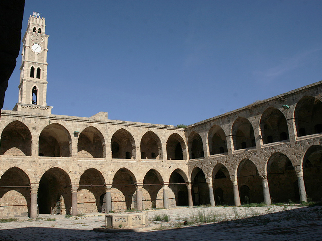 Hodinová věž nad hlavním vchodem do akkského karavanseraje