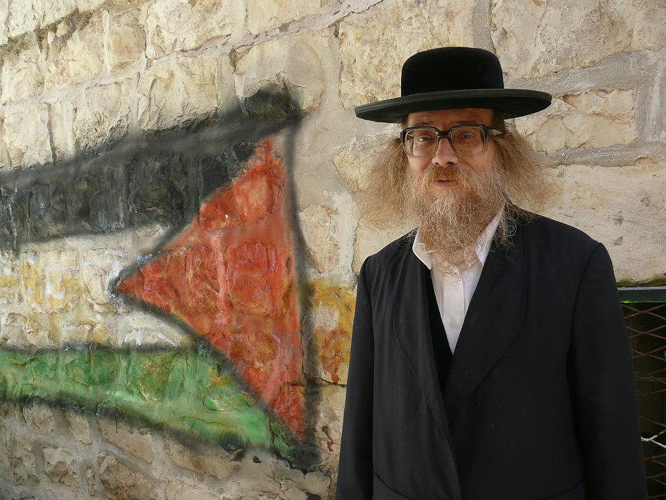 Ne všichni Židé mají na izraelsko-palestinský konflikt jen jednostranný pohled. Ultraortodoxní rabín u palestinské vlajky.