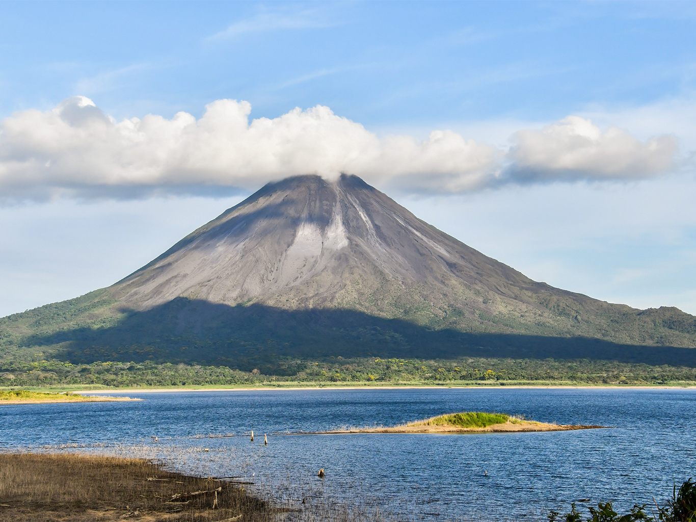 Vulkán Arenal se tyčí nad hladinou největšího kostarického jezera
