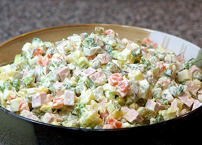Majonézový salát rasols se dělá z masa, sleďů, brambor, hrášku, mrkve a okurky