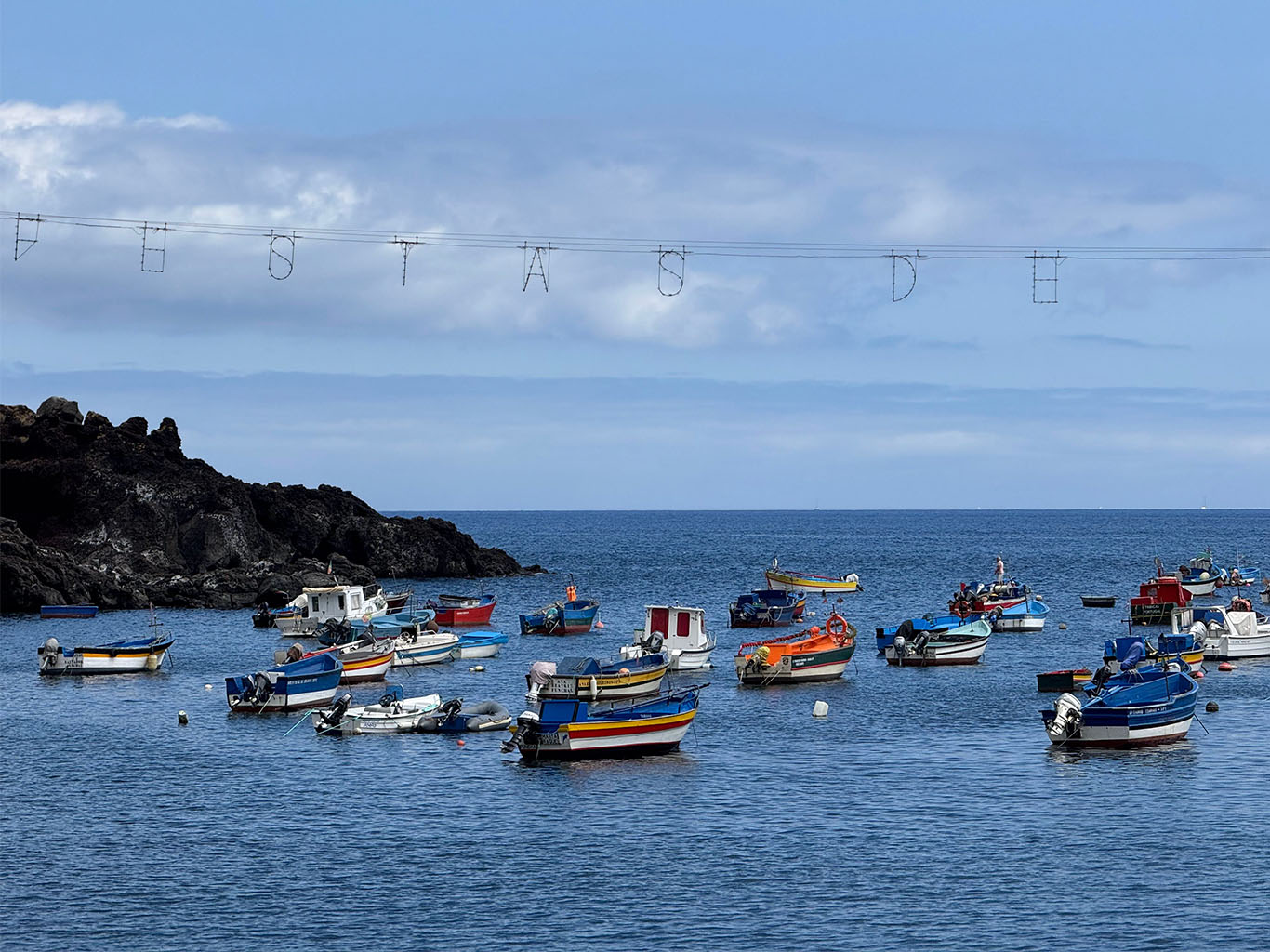 Barevné lodě v zátoce rybářského městečka Câmara de Lobos