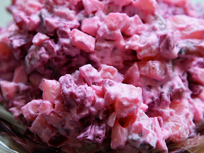 Typicky červeně zbarvený sleďový salát s červenou řepou, okurkou, cibulí a bramborami