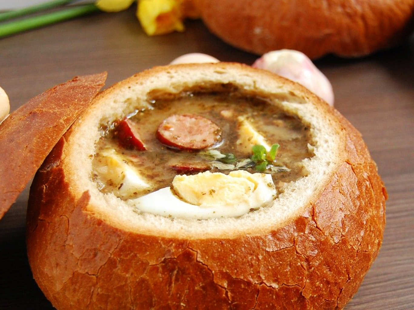 Kyselá polévka żurek se tradičně servíruje v chlebové misce