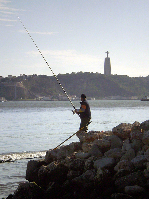 Rybář čeká v deltě řeky Tejo na svůj úlovek
