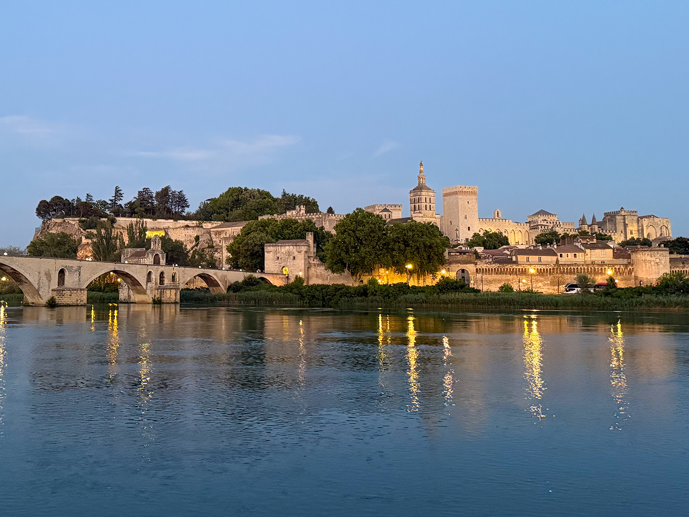 Světla večerního Avignonu odrážející se ve vodách Rhôny
