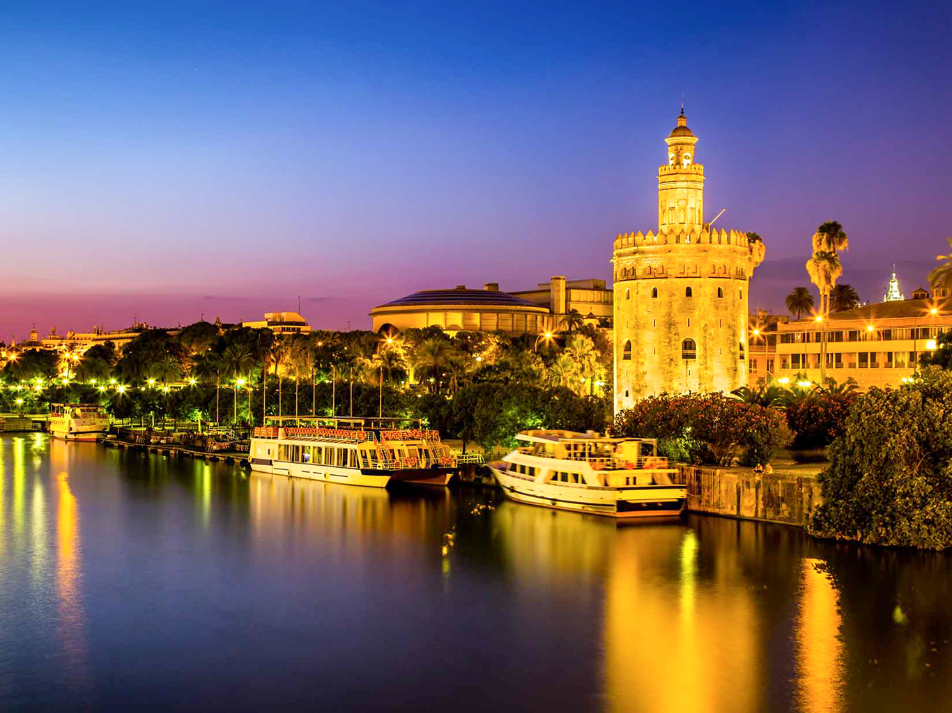 Sevillu chrání strážní věž Torre de Oro u řeky Guadalquivir