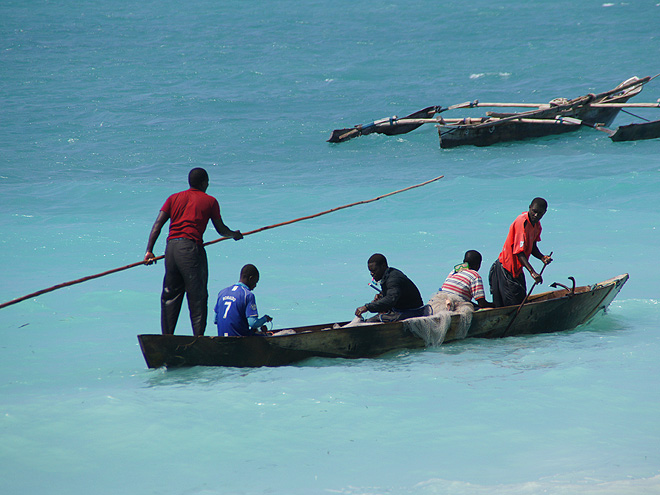 Jednoduché dřevěné rybářské loďky podél pobřeží v Nungwi