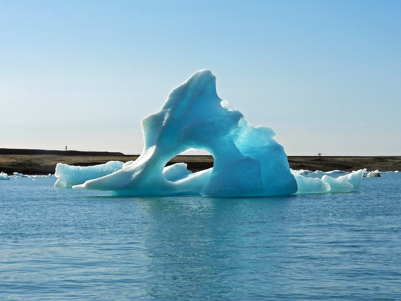 Obrovská tyrkysově modrá ledová kra volně plující po jezeře Jökulsárlón