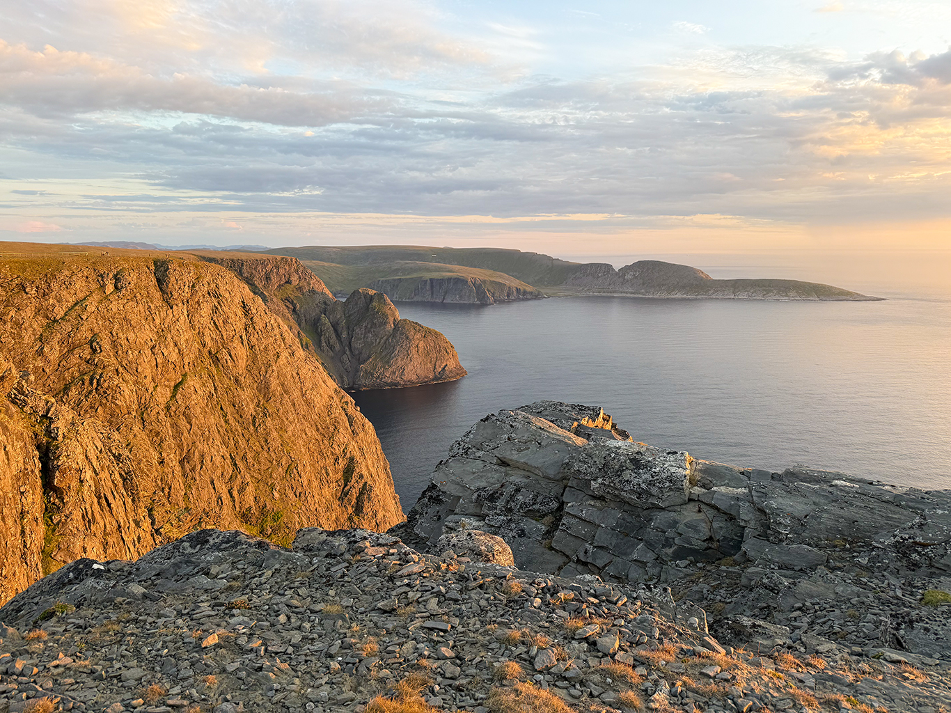 Půlnoční pohled z Nordkappu na skalnatý výběžek Knivskjelodden 