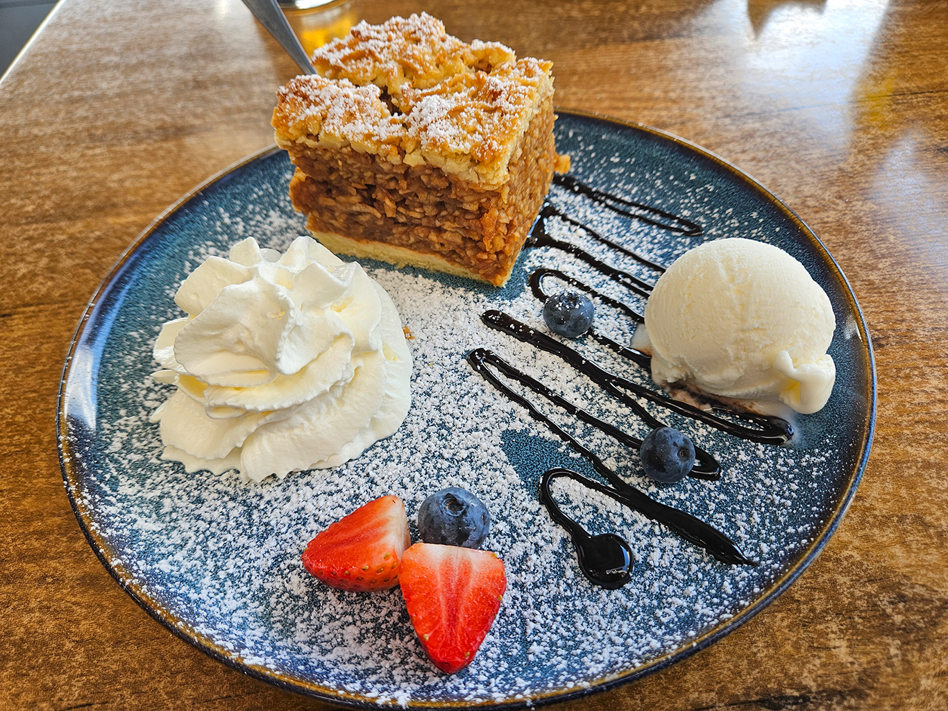 Jablečný dezert szarlotka se často podává teplý, se šlehačkou a zmrzlinou