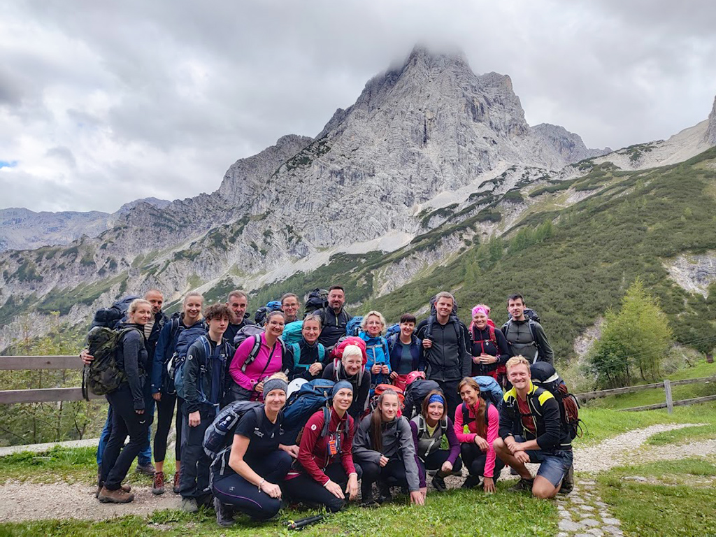 Skupinka ferratistů a turistů s vrcholem Spitzmauer v pozadí