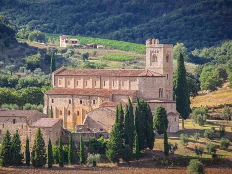Opatství Sant´Antimo nedaleko Montalcina obklopují cypřiše a olivové háje