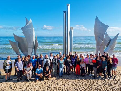 Skupinové foto u památníku Les Braves na pláži Omaha