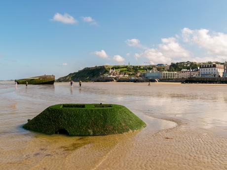 Město Arromanches lemuje dlouhá písečná pláž se silným příběhem