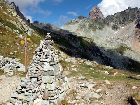 Rozcestník a velký kamenný mužík v sedle Col de Bresson