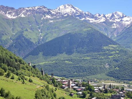 Vrcholy Kavkazu tyčící se nad věžemi Mestie