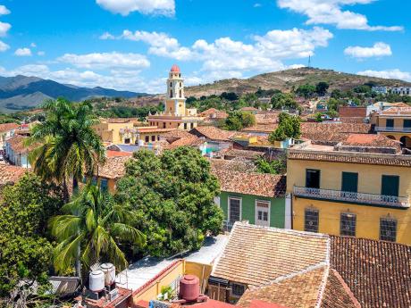 Střechy ospalého Trinidadu s pohořím Sierra del Escambray na dohled