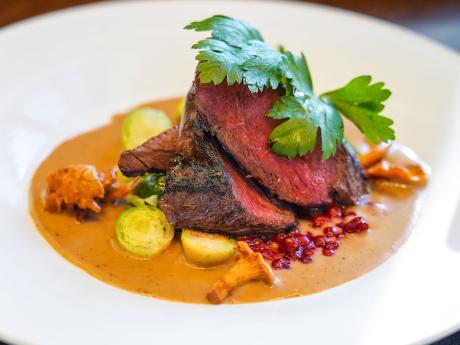 Sobí steak podávaný s vařenými bramborami a brusinkami