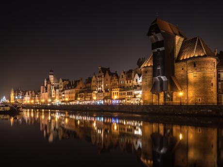 Pohled na noční Gdaňsk se středověkým kladkovým jeřábem 