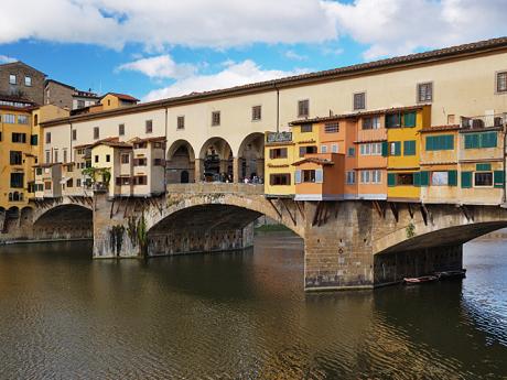 Ponte Vecchio s barevnými krámky po stranách přes řeku Arno ve Florencii
