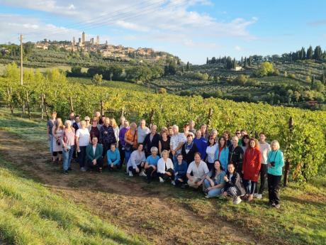 Skupinové foto s typickými vinicemi a městečkem San Gimignano